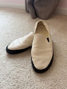 The Row white flats with black trim